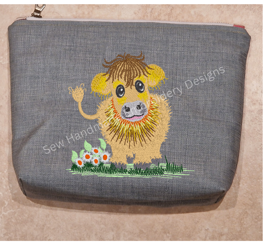 Machine embroidery design of a cute & fluffy Jersey cow with little daisy flowers and standing on a patch of green grass - instand digital download