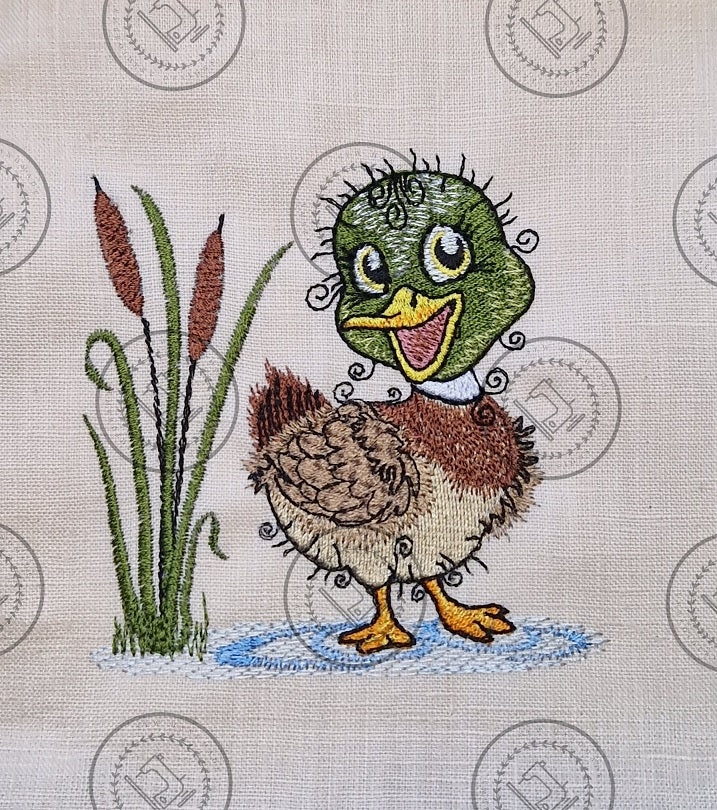 "An embroidered design of a cheerful mallard duck with a vibrant green head, brown and beige body, and yellow beak. The duck is standing in a small blue puddle next to tall cattail reeds, with a whimsical and curly detailing style."