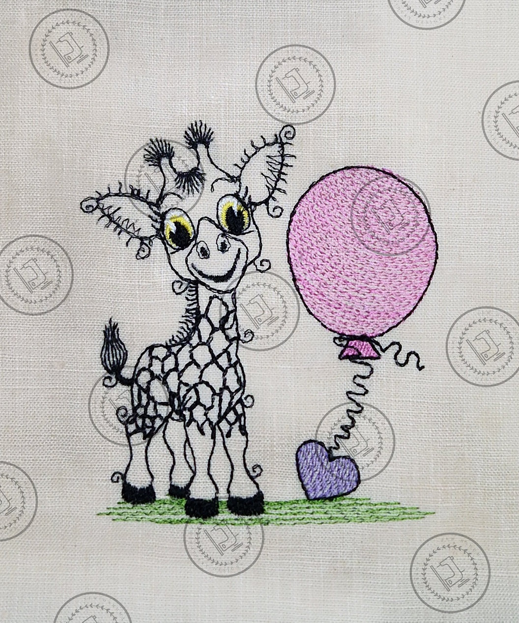 "An embroidered design of a whimsical giraffe with a cheerful expression, featuring exaggerated curly eyelashes and black-patterned spots. The giraffe is standing on a patch of green grass and holding a pink balloon with a curly string tied to a small purple heart."