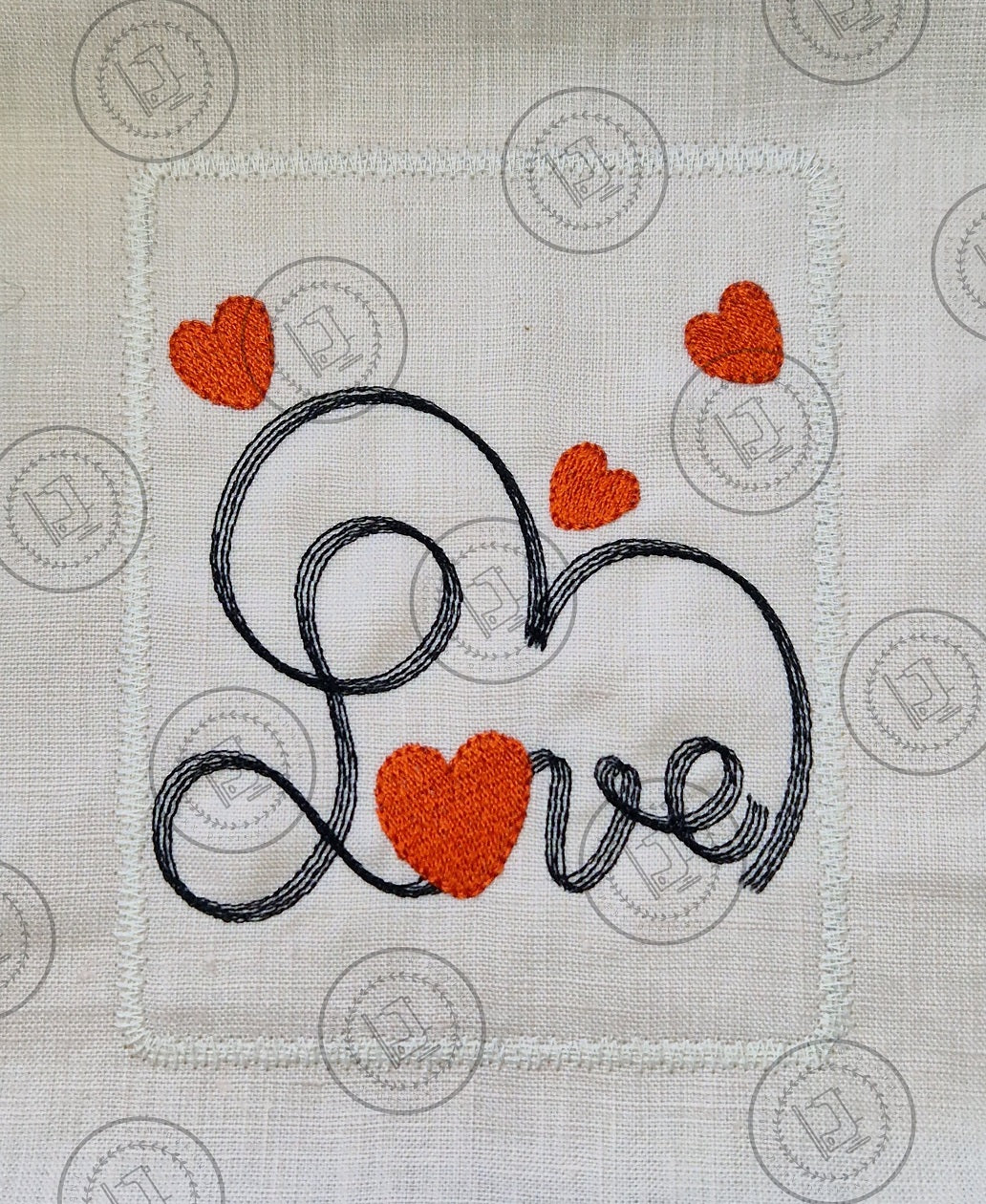 "An embroidered design featuring the word 'Love' in cursive script, stitched with black thread. The letter 'o' is shaped like a red heart, and additional red hearts are scattered decoratively around the design on a light fabric background."